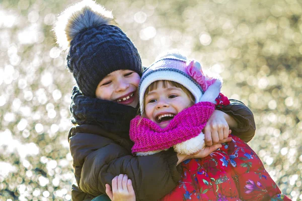 两个快乐的男孩和女孩在阳光明媚的冬季户外玩耍 — 图库照片