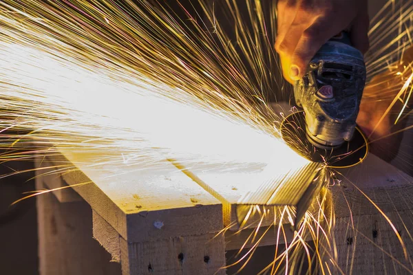 Primer plano de las manos de los trabajadores cortando metal con amoladora. Chispas mientras — Foto de Stock