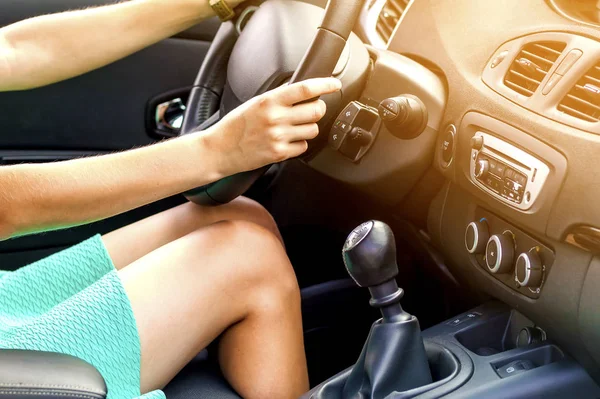 Bela mulher bronzeada pernas de motorista magro em um carro. Menina de vestido — Fotografia de Stock
