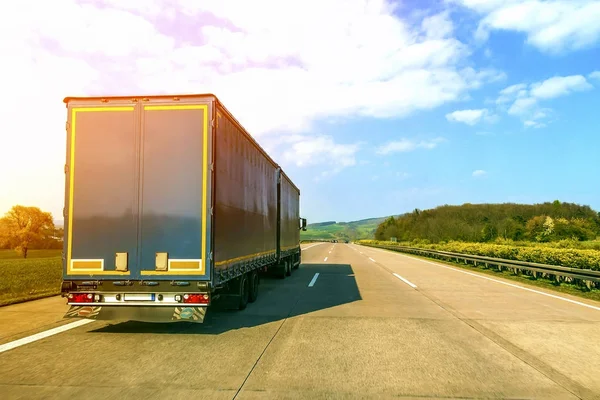 Blauwe lading vrachtwagen op een lege snelweg — Stockfoto