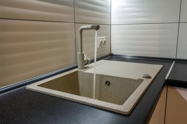 Fregadero de granito y grifo de agua en el interior de la nueva cocina moderna — Foto de Stock