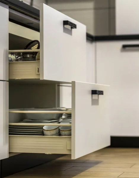 Открытые кухонные ящики с тарелками и чашками посуды — стоковое фото