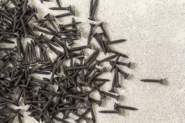 Yakın çekim yansıma beton zemin üzerine birçok küçük siyah vidalar