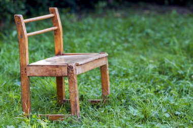 Yeşil çimenlerin üzerinde küçük eski sandalye