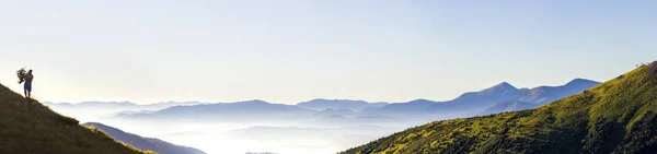 Amplo panorama de colinas de montanha matinais e turista caminhante solitário — Fotografia de Stock