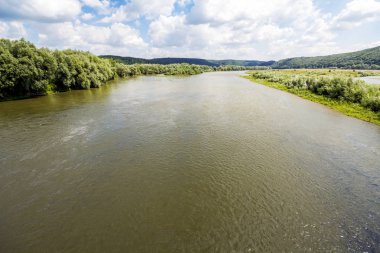 Geniş nehir kenarında bulunan yeşil ağaçlar ile yaz aylarında su