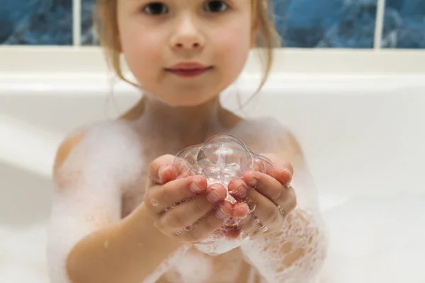 Чайлдс маленькие девочки руки в ванне с мыльными пузырями в нем. Hygie — стоковое фото