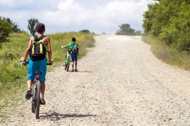 Güneşli bir günde bir çakıl yol bisiklet sürme çocuk çocuklar