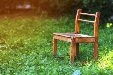 Yeşil çimenlerin üzerinde küçük eski sandalye