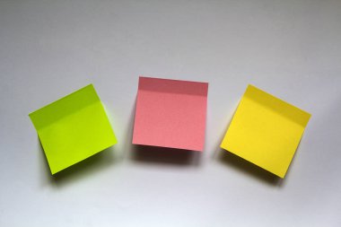 Beyaz duvar arka plan üzerinde izole boş renkli yapışkan notlar