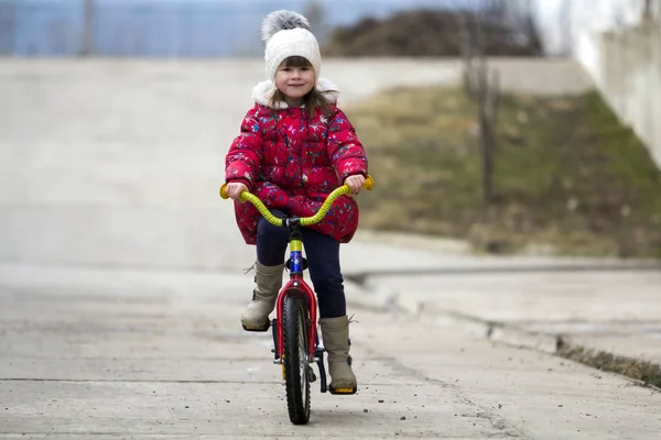 公園で美しいの笑みを浮かべて小さな女の子の乗馬の自転車 — ストック写真
