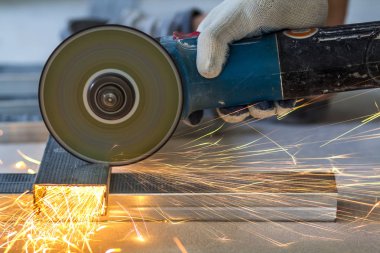 İşçi kesme metal taşlama ile yakın çekim. Sparks sırıtış süre