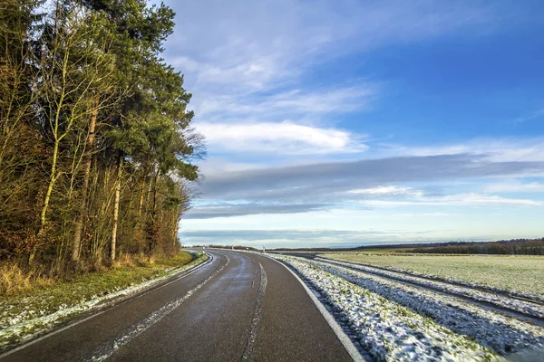 Lege zwarte asfaltweg tussen de groene velden — Stockfoto