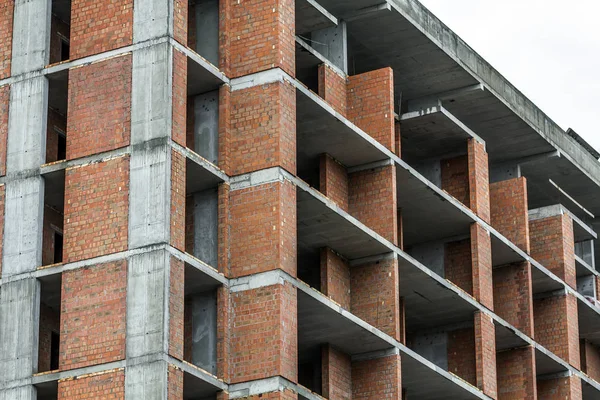 Vista de detalle de cerca de un nuevo edificio residencial moderno obras de construcción en construcción. Concepto de desarrollo inmobiliario. Casa de varios pisos de ladrillos y hormigón . —  Fotos de Stock