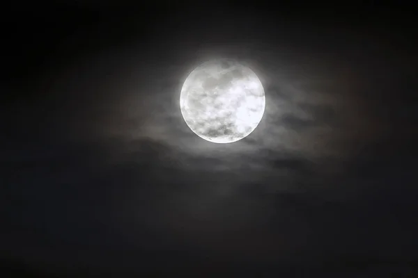 Grande lune argentée en gros plan sur ciel bleu foncé avec des nuages épars . — Photo