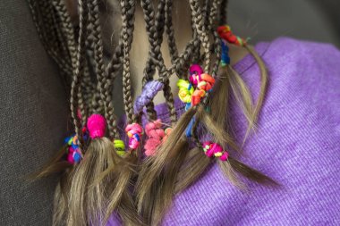 Close up of braid hair of little girl with colorful rubber bands clipart