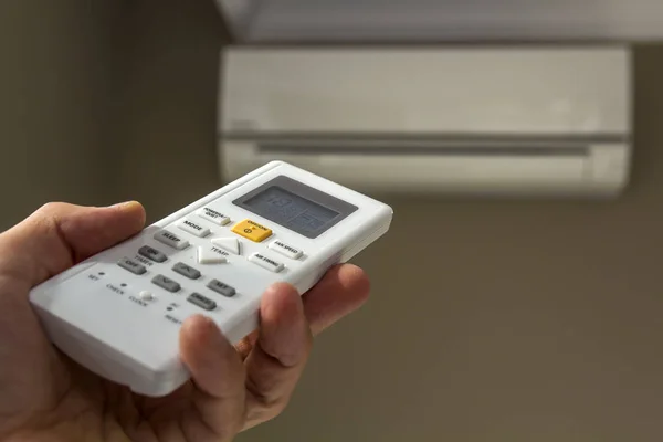 Hand holdind controleschakelaar van huis airconditioner — Stockfoto