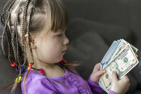 Money, finances and people concept - smiling little girl with dollar cash money. Stock Photo