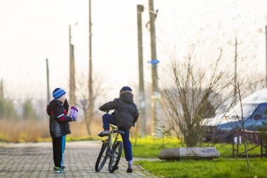 Bir bisiklet erkek arkadaşlar. Çocuklar açık havada oyun