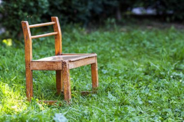 Yeşil çimenlerin üzerinde küçük eski sandalye