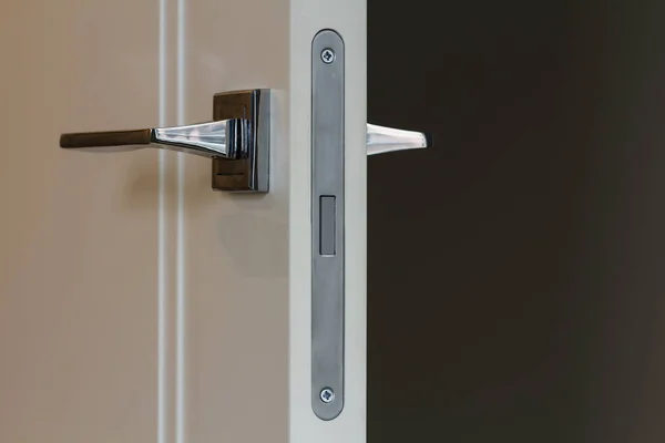 Klamka ze stali nierdzewnej nowoczesny na białe drzwi drewniane — Zdjęcie stockowe