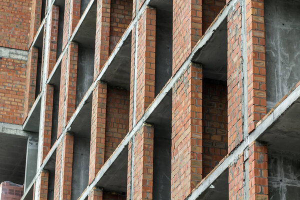 Close-up detail view of a new modern residential house building construction site work under construction. Real estate development concept. Multi story home from bricks and concrete.