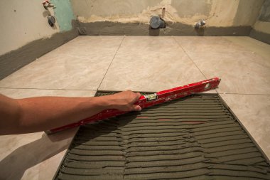 Seramik kiremit ve çatı ustası için araçlar. İşçi el yükleme yer karosu. Ev geliştirme, yenileme - Seramik Karo döşeme yapıştırıcı, harç, düzeyi.