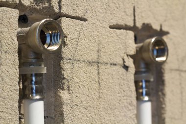 Su boruları evde sıhhi tesisat duvardaki polipropilen yapılmıştır. Kanalizasyon boruları bir daire iç banyoda yükleme yenileme çalışmaları sırasında. Gri plastik drenaj borusu için kullanılan su