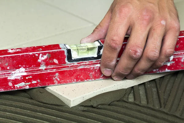 Baldosas y herramientas cerámicas para tiler. Trabajador mano instalación piso — Foto de Stock