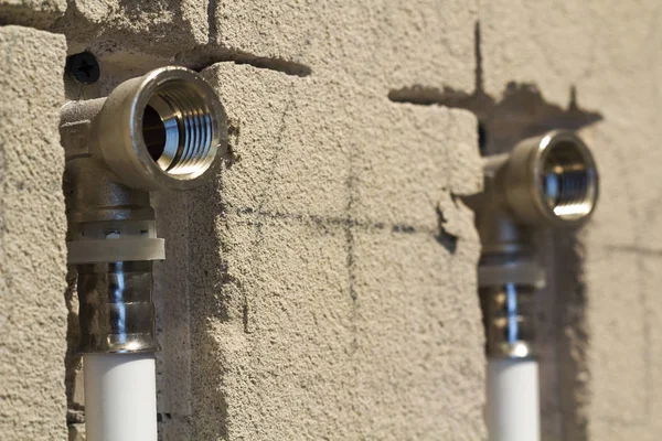 Water pipes made of polypropylene in the wall, plumbing in the house. Installation of sewer pipes in a bathroom of an apartment interior during renovation works. Gray plastic drain pipe for used water