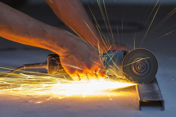 Primer plano de las manos de los trabajadores cortando metal con amoladora. Chispas mientras — Foto de Stock