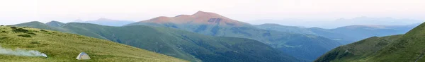 Panorama de montaña con tienda turística. Salida o puesta del sol en mounta — Foto de Stock