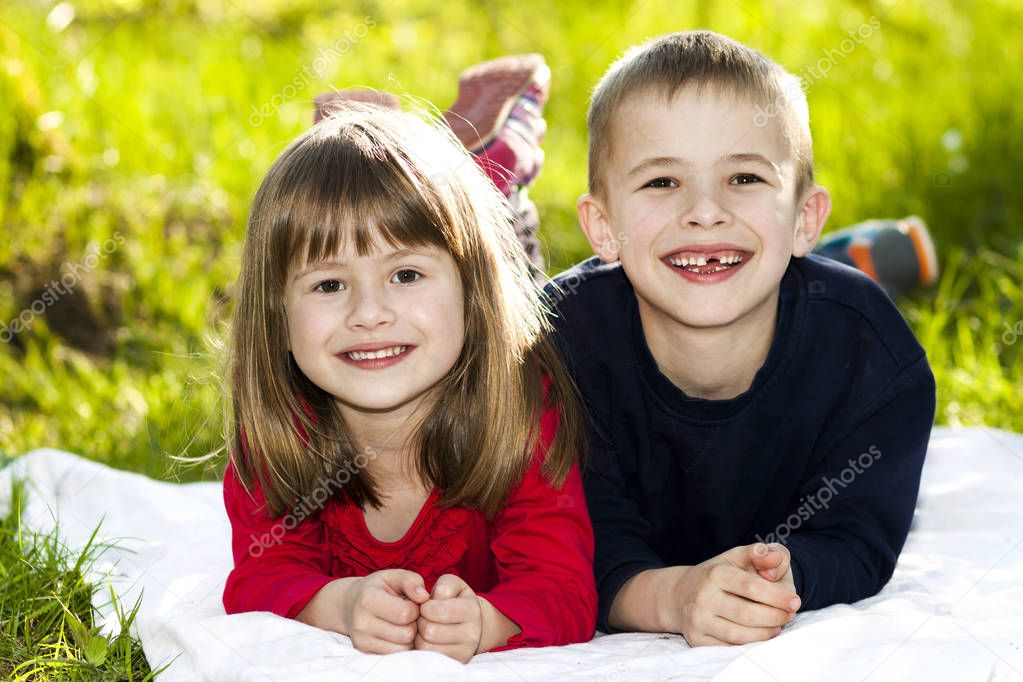 Portrait of happy smiling little children boy and girl on sunny 