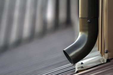 Kahverengi yeni cilt payı metal sistem boru. Duvardaki çatı binadan yağmur suyu drenaj için dikey inşaat. Drenaj koruma.