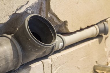 Kanalizasyon boruları bir daire iç banyoda yükleme yenileme çalışmaları sırasında. Gri plastik drenaj borusu için kullanılan su.