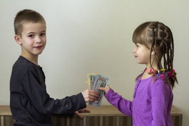 İki küçük çocuk erkek ve kız dolar para ile oynamak.