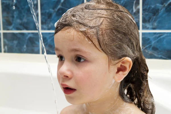 Маленькая девочка в ванной, моет голову. Символ чистоты — стоковое фото