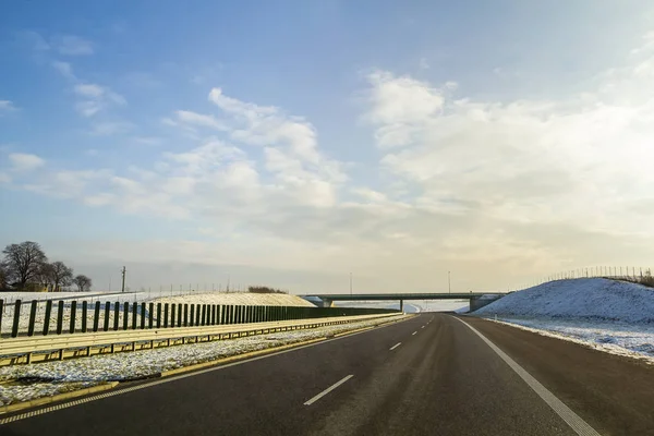 Winterlandschap met asfaltweg naar de horizon. — Stockfoto