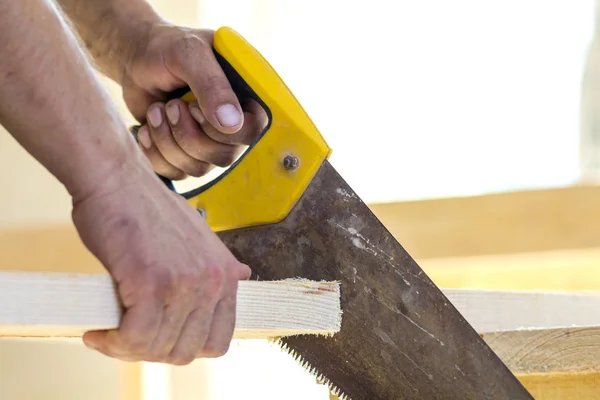 Mão de carpinteiro com serra de corte de placas de madeira — Fotografia de Stock