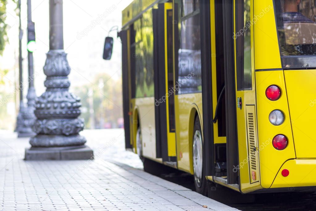 Modern yellow city bus with open doors at bus station