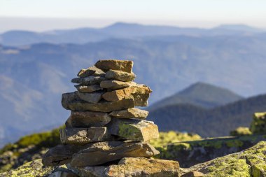 Taş yığını Dağları arka plan üzerinde bir dağın tepesinde yosun kaplı. Denge ve uyum kavramı. Zen yığını kayalar. Vahşi doğa ve Jeoloji detay.