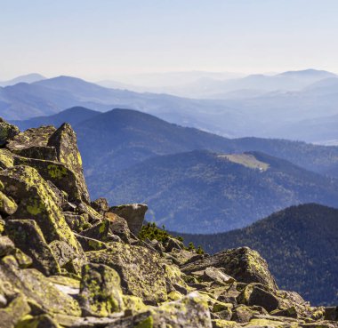 Taş yığını Dağları arka plan üzerinde bir dağın tepesinde yosun kaplı. Denge ve uyum kavramı. Zen yığını kayalar. Vahşi doğa ve Jeoloji detay.