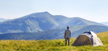 Karpat Dağları'nda kamp çadır yakınındaki ayakta uzun yürüyüşe çıkan kimse adam. Hedef