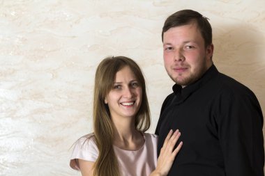 Genç yakışıklı portresi sakallı adam ve güvenle kameraya gülümseyen güzel pembe elbiseli uzun sarı saçlı güzel kadın.