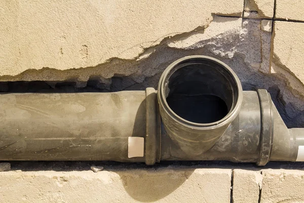 Монтаж каналізаційних труб у ванній кімнаті інтер'єру квартири під час ремонтних робіт. Сіра пластикова труба для стічних вод . — стокове фото