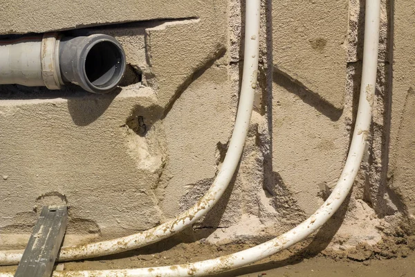 Instalação de tubos de esgoto em um banheiro de um apartamento interior durante obras de renovação. Tubulação de drenagem de plástico cinza para água usada . — Fotografia de Stock