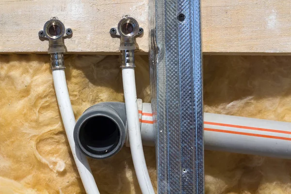 Tuyaux d'eau en polypropylène dans le mur, plomberie dans la maison. Installation de tuyaux d'égout dans une salle de bain d'un intérieur d'appartement pendant les travaux de rénovation. Tuyau de vidange en plastique gris pour eau usée — Photo