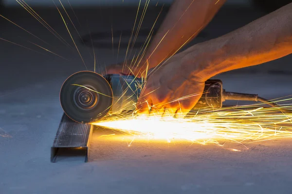 Primer plano de las manos de los trabajadores cortando metal con amoladora. Chispas mientras — Foto de Stock