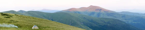 Горная панорама с туристической палаткой. Восход солнца или закат в горах — стоковое фото