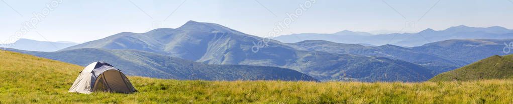 Mountain panorama with tourist tent. Sunrise or sunset in mounta